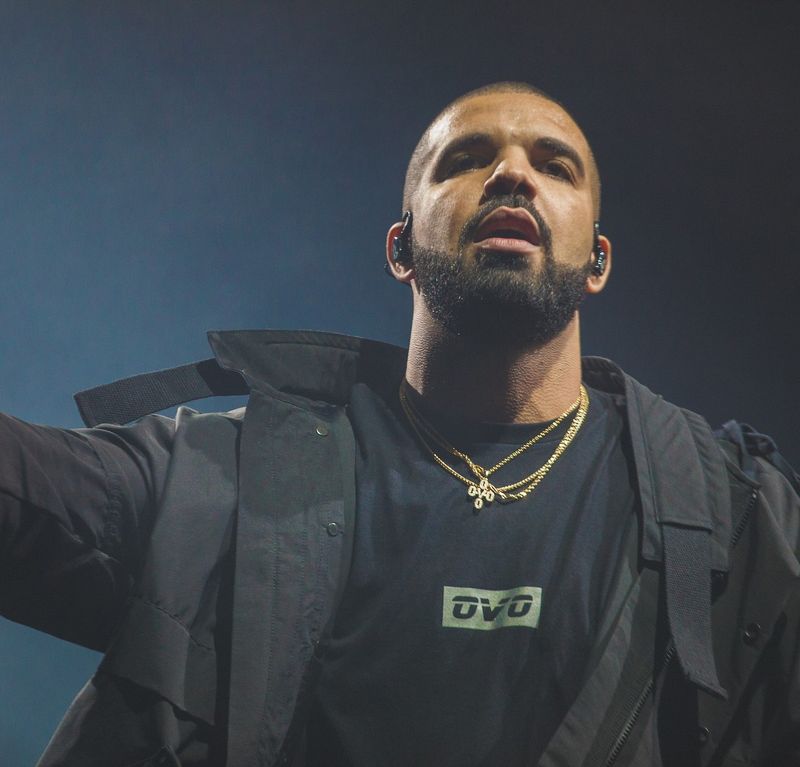 Drake performing on stage in an OVO shirt