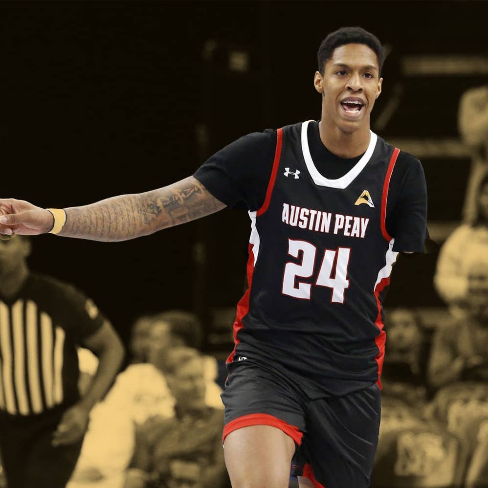Hansel Enmanuel in his black Austin Peay number 24 jersey mid-game — his left arm visibly shortened, the one-armed hooper