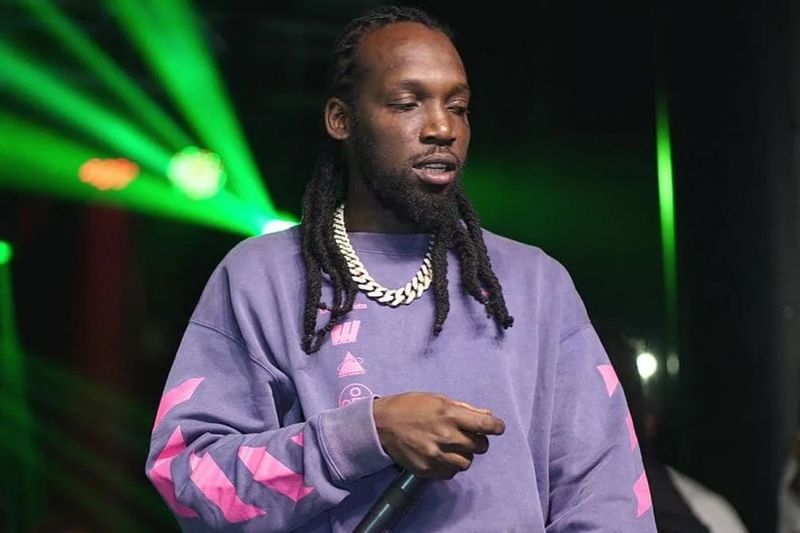 Mavado performing live on stage under green concert lights